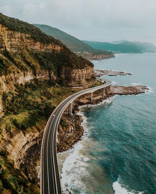 Vista aérea de la carretera por el mar y la montaña contra el cielo