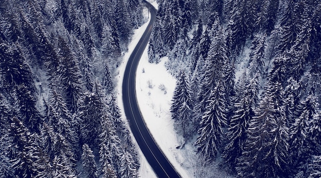 Vista aérea de una carretera de montaña en el bosque de invierno. Alpes Dolomitas Italia.