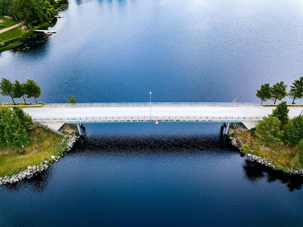 Vista aérea de la carretera del puente cerca del lago azul en el paisaje de verano en la Finlandia rural