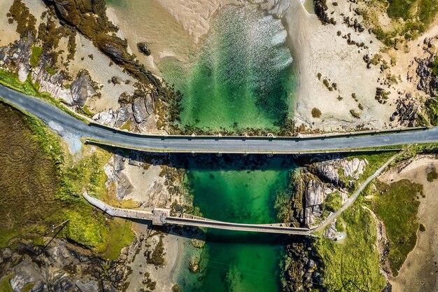 Foto vista aérea de una carretera que conecta las costas en un día soleado en donegal