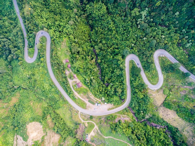 Foto vista aérea de una carretera sinuosa en medio de árboles en el bosque