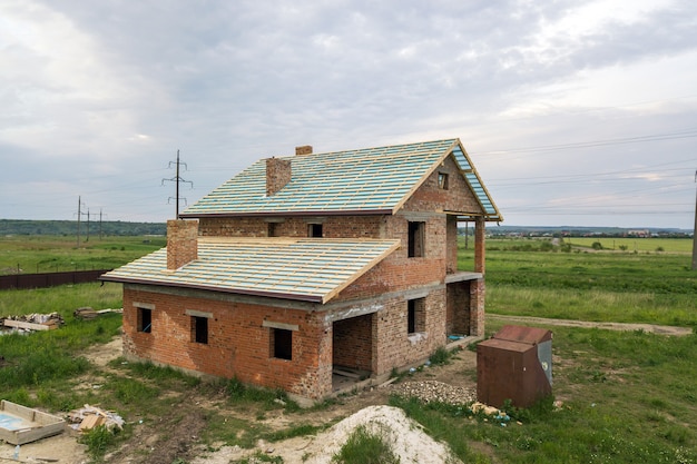 Vista aérea de una casa de ladrillo con techo de madera en construcción.