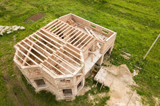 Vista aérea de una casa de ladrillo con techo de madera en construcción.