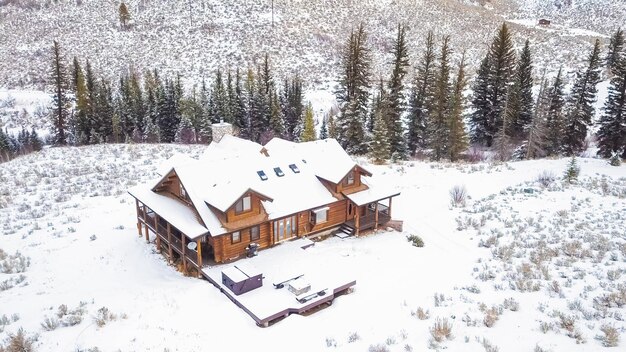 Vista aérea de la casa de montaña cubierta de nieve en invierno.