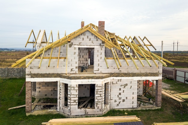 Vista aérea de una casa privada con paredes de ladrillo de hormigón celular y estructura de madera para el futuro techo.