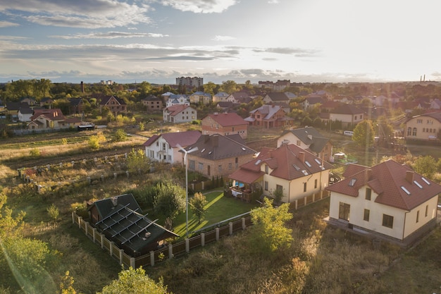 Vista aérea de una casa privada residencial con paneles solares en el techo y turbina eólica