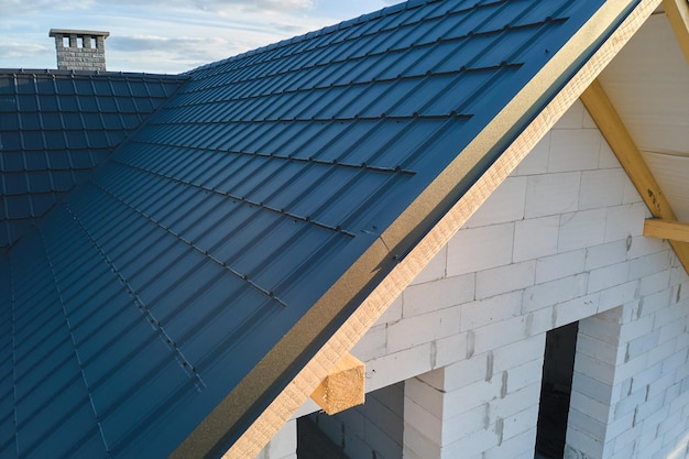 Vista aérea de la casa sin terminar con paredes de hormigón ligero aireado y techo de madera cubierto con tejas metálicas en construcción.