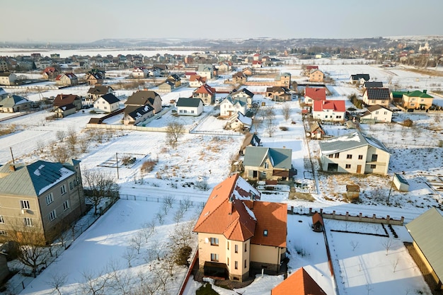 Vista aérea de casas residenciales con techos cubiertos de nieve en el área suburbana de la ciudad rural en invierno