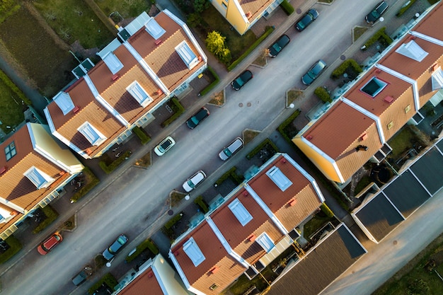 Vista aérea de casas residenciales con techos rojos y calles con automóviles estacionados en la zona rural de la ciudad. Suburbios tranquilos de una ciudad europea moderna.