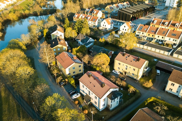 Vista aérea de casas residenciales con techos rojos y calles con autos estacionados en la zona de la ciudad rural. Suburbios tranquilos de una ciudad europea moderna.