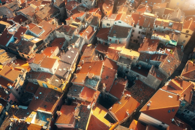 Vista aérea de casas con techos naranjas al atardecer en verano en Rovinj Croacia Vista superior de la hermosa arquitectura en la ciudad vieja Edificios del centro histórico calle Viajes Paisaje colorido