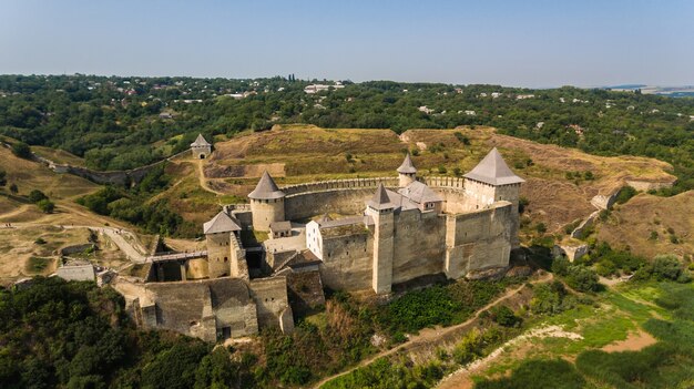 Vista aérea del castillo medieval de Khotyn en la colina verde sobre el río.