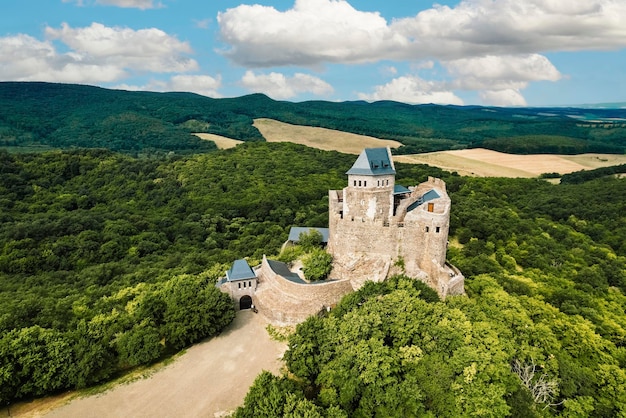 Vista aérea del castillo medieval en ruinas de Holloko, sitio del patrimonio mundial de la UNESCO en Hungría, castillo histórico en las montañas de Hungría