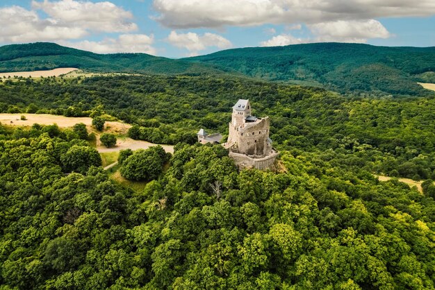 Vista aérea del castillo medieval en ruinas de Holloko, sitio del patrimonio mundial de la UNESCO en Hungría, castillo histórico en las montañas de Hungría