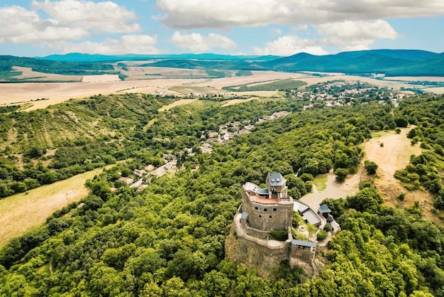 Vista aérea del castillo medieval en ruinas de Holloko, sitio del patrimonio mundial de la UNESCO en Hungría, castillo histórico en las montañas de Hungría