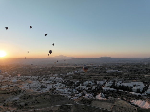 Vista aérea cinematográfica de um balão de ar quente colorido voando sobre a Capadocia