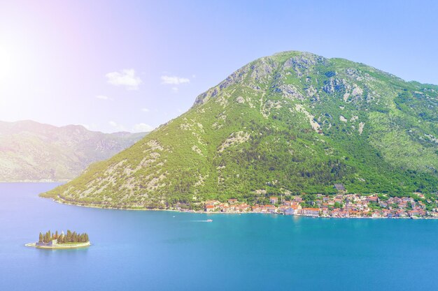 Foto vista aérea de la ciudad al pie de la montaña y una isla con un monasterio en el mar