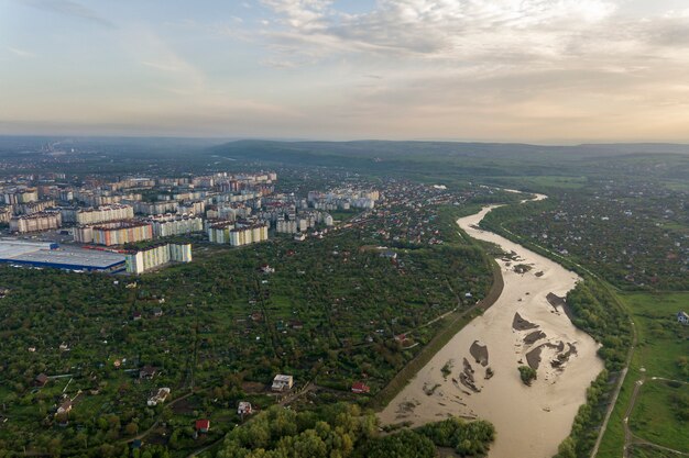 Vista aérea de la ciudad de Ivano-Frankivsk con zona residencial y casas suburbanas con un río en el medio.