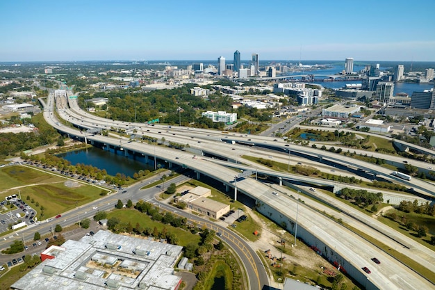 Vista aérea de la ciudad de Jacksonville con altos edificios de oficinas e intersección de autopistas estadounidenses con automóviles y camiones de movimiento rápido Concepto de infraestructura de transporte de EE. UU.