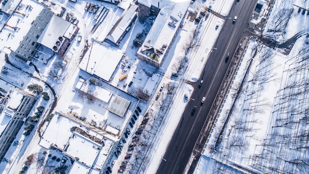 Vista aérea de la ciudad en el panorama de la ciudad de día de invierno con camino recto cubierto de nieve de un ojo de pájaro