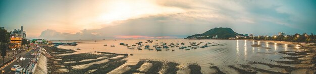 Vista aérea de la ciudad de Vung Tau con hermosa puesta de sol y tantos barcos Vista panorámica costera de Vung Tau desde arriba con olas, calles costeras, cocoteros y la montaña Tao Phung en Vietnam