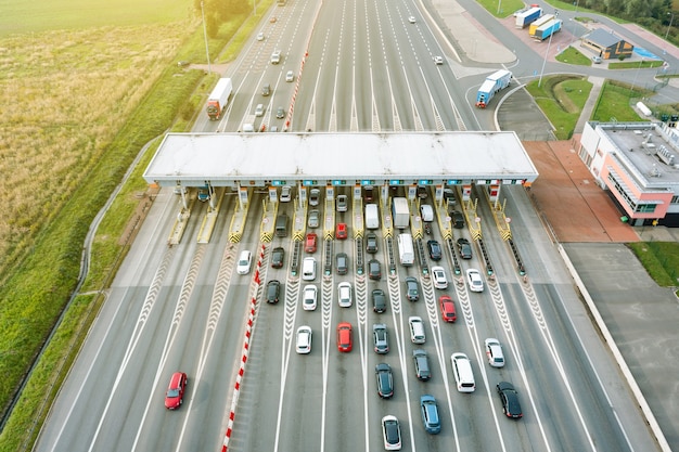 Una vista aérea de una concurrida carretera de peaje con muchos coches haciendo cola para pagar el peaje de la autopista