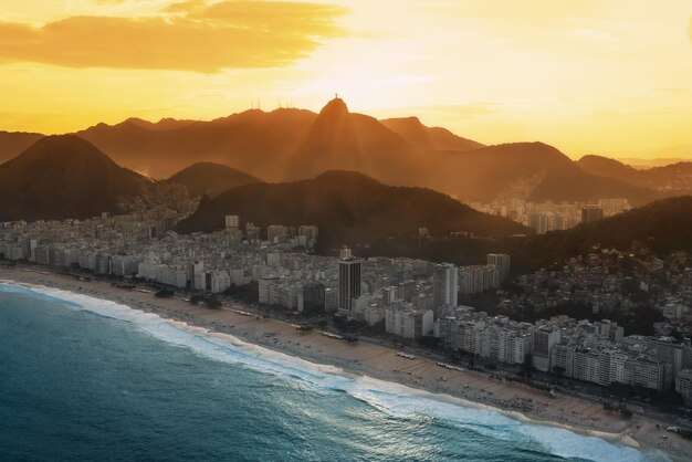 Foto vista aérea de copacabana al atardecer con la montaña corcovado en río de janeiro, brasil