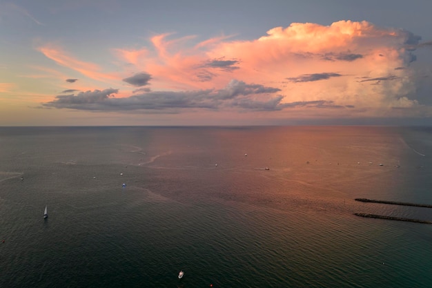 Vista aérea de la costa cerca de Venecia Florida con yates blancos al atardecer flotando en las olas del mar Jetty Norte y Sur en la playa de Nokomis Recreación en barco de motor en la superficie del océano