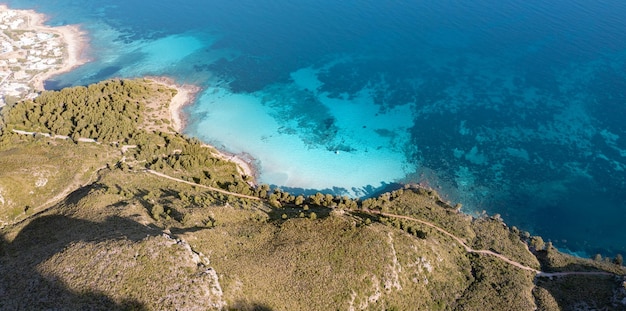 Vista aérea de la costa del Mar Mediterráneo en Mallorca con una playa de arena blanca y aguas turquesas