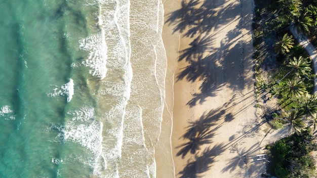 Vista aérea de la costa rocosa en un tranquilo mar azul eléctrico