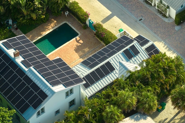 Vista aérea del costoso techo de una casa estadounidense con paneles solares fotovoltaicos azules para producir energía eléctrica ecológica limpia Invertir en electricidad renovable para los ingresos de jubilación