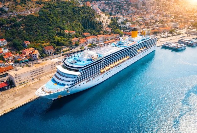 Vista aérea del crucero en el puerto al atardecer en Dubrovnik Croacia Hermosos barcos barcos y yates Paisaje con puerto ciudad montañas mar azul Crucero de lujo Vista superior del transatlántico flotante