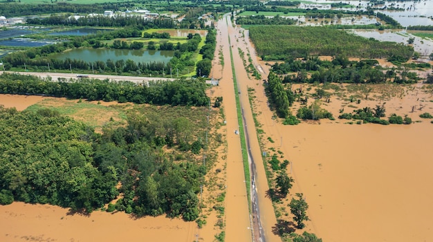 Vista aérea da aldeia inundada e estrada rural com carro, vista de cima filmada por drone