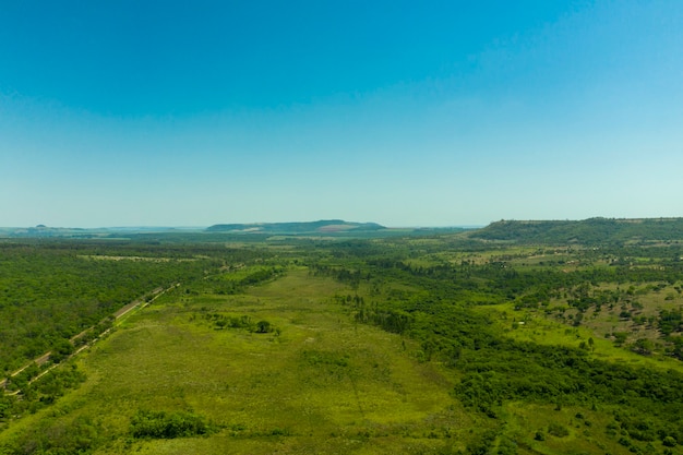 Vista aérea da área com bosques ao lado da rodovia e montanhas