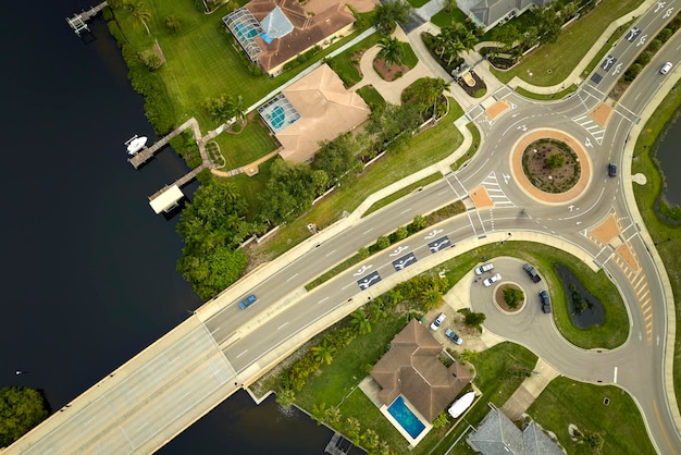 Vista aérea da área suburbana americana com cruzamento de rotatória de estrada rural com tráfego de carros em movimento Cruzamento de transporte circular na Flórida