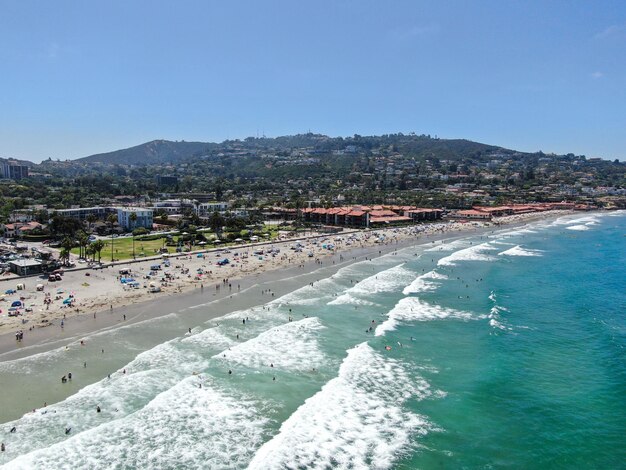 Vista aérea da baía de La Jolla com boas ondas pequenas e turistas aproveitando o dia de praia