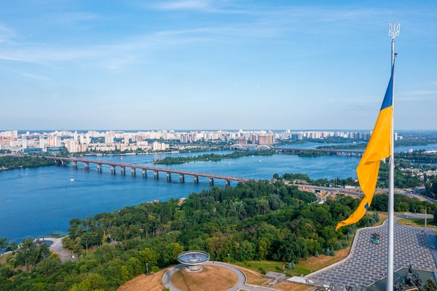 Vista aérea da bandeira ucraniana balançando ao vento contra a cidade de Kyiv