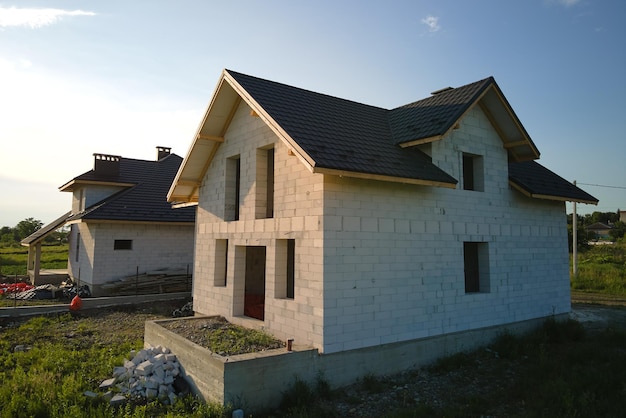 Vista aérea da casa inacabada com paredes de concreto leve aeradas e estrutura de telhado de madeira coberta com telhas metálicas em construção