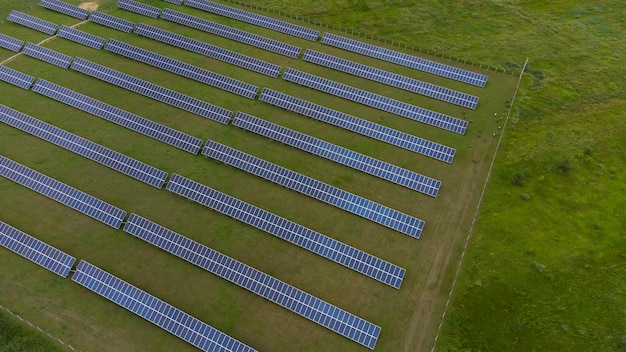 Vista aérea da célula solar da fazenda de painéis solares com luz solar. Voo de drone sobre campo de painéis solares, conceito de energia alternativa verde renovável.