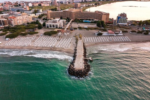 Vista aérea da cidade de Pomorie, localizada na costa do mar Negro. Vista superior das praias de areia com muitos edifícios de hotéis e infraestrutura turística.