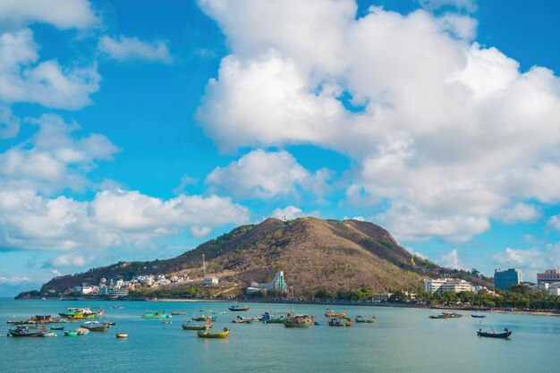 Vista aérea da cidade de Vung Tau com belo pôr do sol e tantos barcos Vista panorâmica costeira de Vung Tau de cima com ondas do litoral ruas coqueiros e montanha Tao Phung no Vietnã