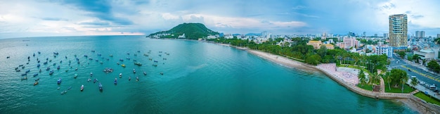 Vista aérea da cidade de Vung Tau com belo pôr do sol e tantos barcos Vista panorâmica costeira de Vung Tau de cima com ondas do litoral ruas coqueiros e montanha Tao Phung no Vietnã