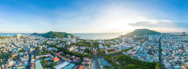 Vista aérea da cidade de Vung Tau com belo pôr do sol e tantos barcos Vista panorâmica costeira de Vung Tau de cima com ondas do litoral ruas coqueiros e montanha Tao Phung no Vietnã