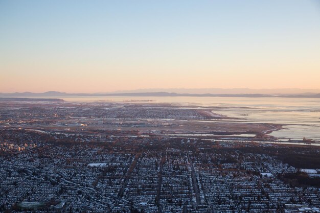 Vista aérea da cidade e do aeroporto à distância durante um pôr do sol vibrante