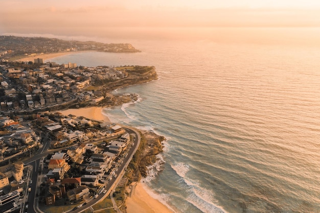 Vista aérea da cidade pelo mar contra o céu durante o pôr do sol