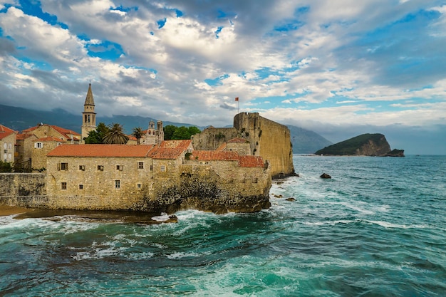 Vista aérea da cidade velha de Budva com poderosas ondas do mar, famoso local turístico em Montenegro