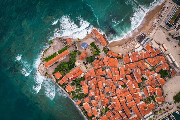 Vista aérea da cidade velha de budva com poderosas ondas do mar, famoso local turístico em montenegro