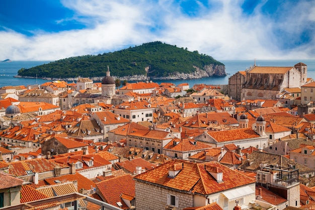 Vista aérea da cidade velha de Dubrovnik com suas casas de telhados vermelhos e a ilha Lokrum ao fundo, Croácia