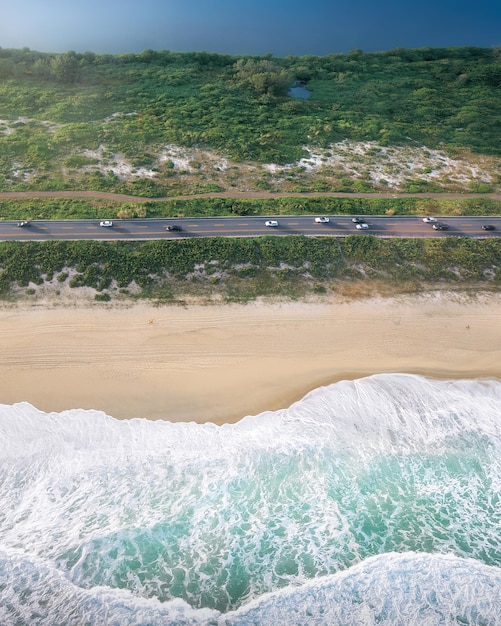 Foto vista aérea da estrada com praia, ondas do mar, lago e natureza em barra da tijuca, rio de janeiro, brasil