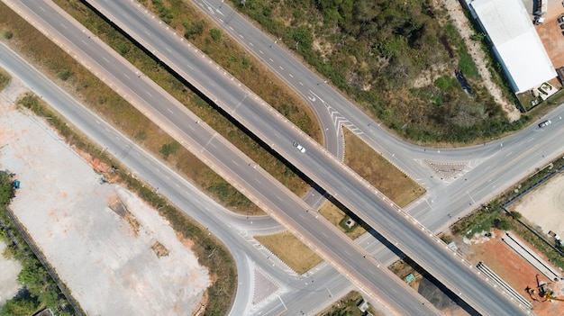 Vista aérea da estrada da rodovia estrada de junção da cidade de transporte com o carro na interseção cruzada